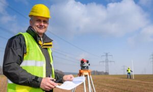 Licensed land surveyor in Kingman measuring land elevations for a FEMA Flood Elevation Certificate