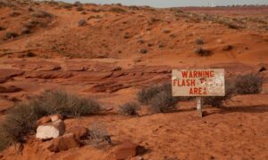 Warning flash flood area sign in desert landscape highlighting risks that make a boundary line survey important for protecting property lines