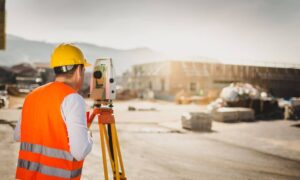 Licensed land surveyor preparing a flood elevation certificate for a property in a high-risk flood zone