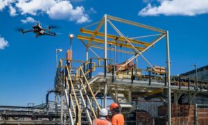 Surveyors operating survey drones at a construction site to capture mapping data under FAA BVLOS rules