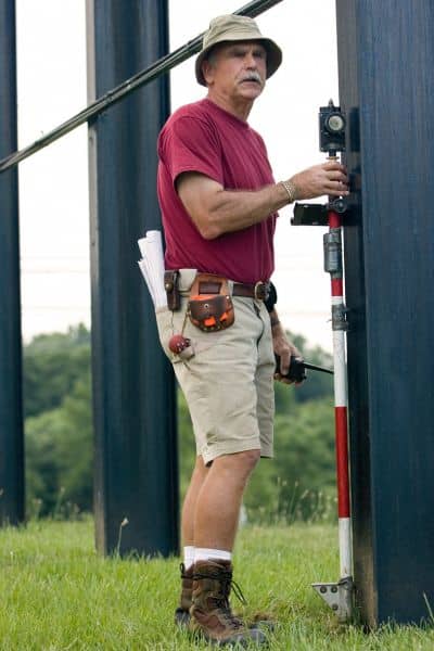 Field surveyor measuring equipment outdoors - ALTA SURVEY Arizona Surveyor using measuring equipment in the field, showing the hands-on work behind accurate mapping and due diligence surveys