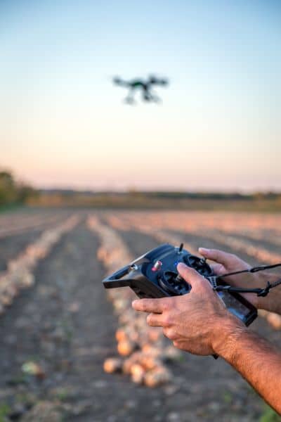 Surveyor operating drone fieldwork - ALTA SURVEY Arizona Surveyor operating a drone during a field survey to collect aerial data for site planning and mapping