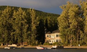 Waterfront house shoreline rising water level - ALTA SURVEY Arizona A lakeside home with boats docked along the shoreline, showing how shifting water levels can affect property boundaries and the need for a due diligence survey