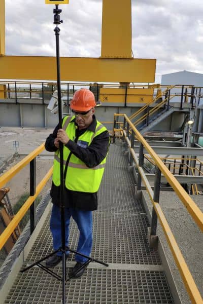 A surveyor using RTK equipment to gather elevation data for a topographic survey during early project planning