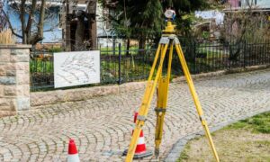 Land surveyor using total station on site - ALTA SURVEY Arizona Licensed land surveyor performing a boundary line survey using a total station to verify property lines