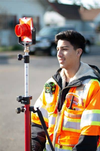 Land surveyor measuring property boundaries with field equipment before land is divided