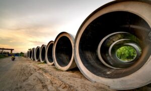 Large concrete pipes at an active construction site, relevant to construction survey work